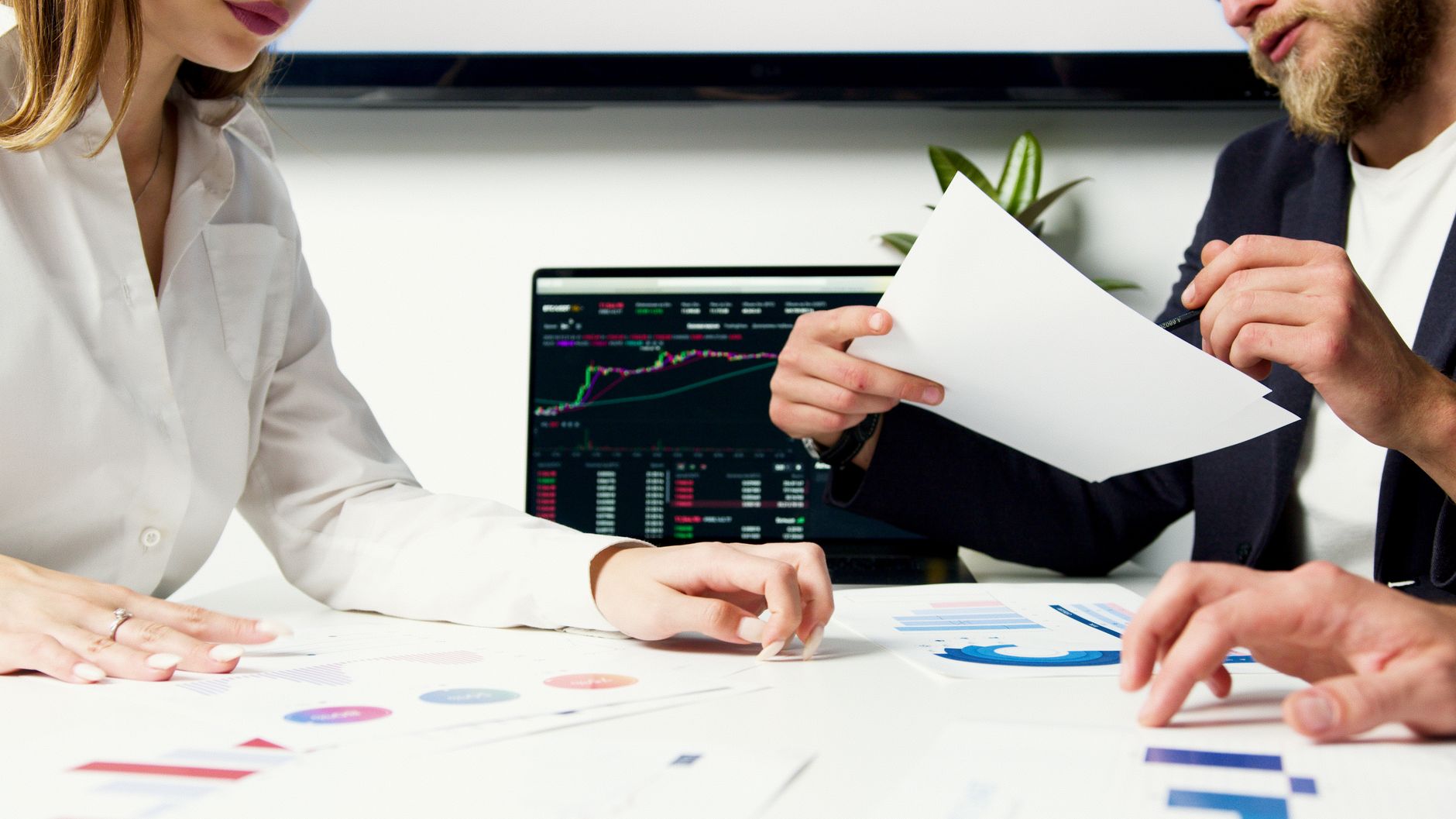 A team of television analysts examining analytics charts